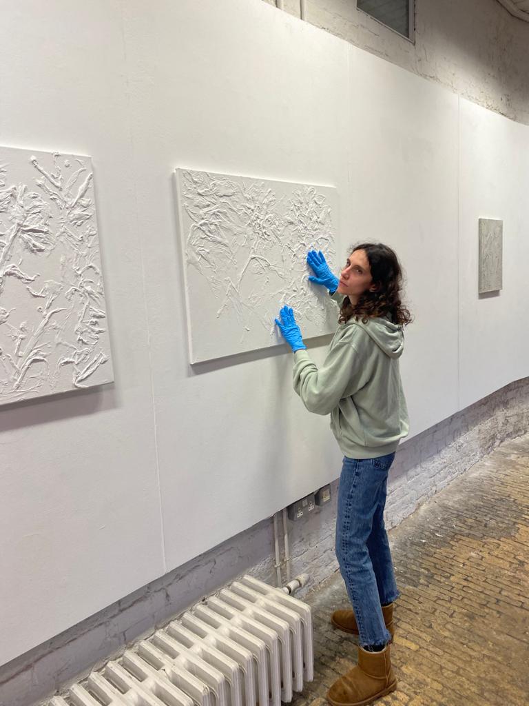 Raffaella, touching her artwork whilst overseeing the installation of her solo exhibition 'Hushed Impressions'. January 2023. 